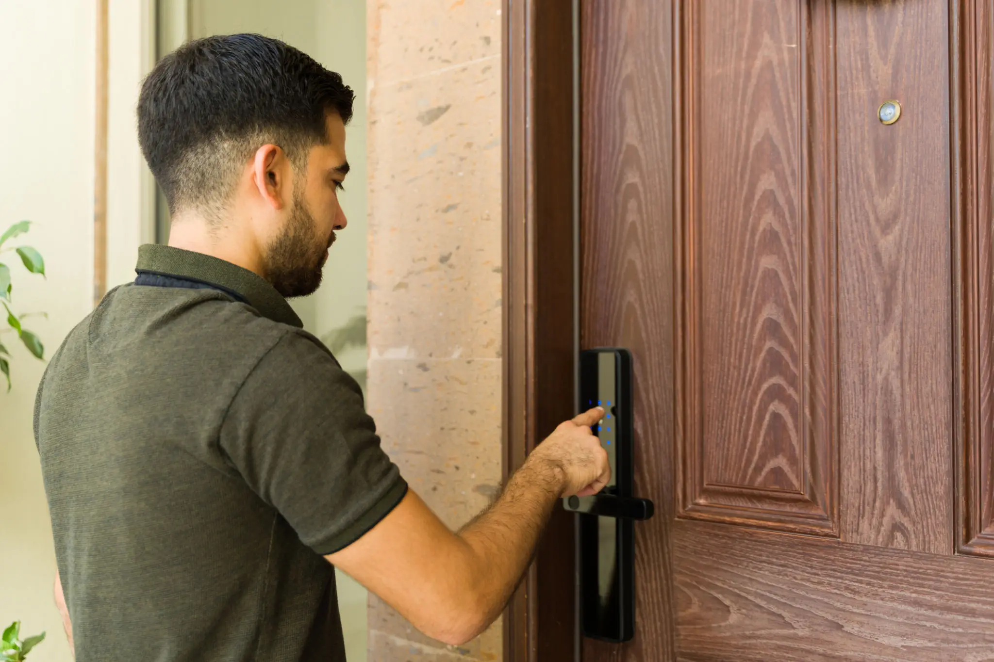 Man unlocking a wooden door with a key card.