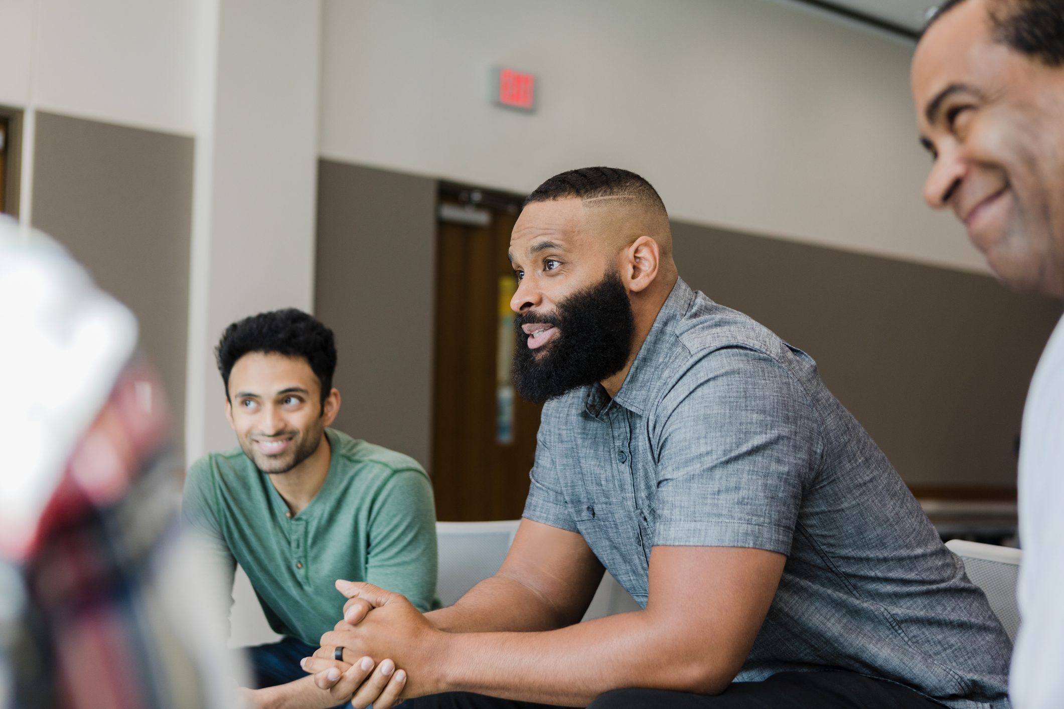 Two men engaged in a lively discussion in a modern office setting.