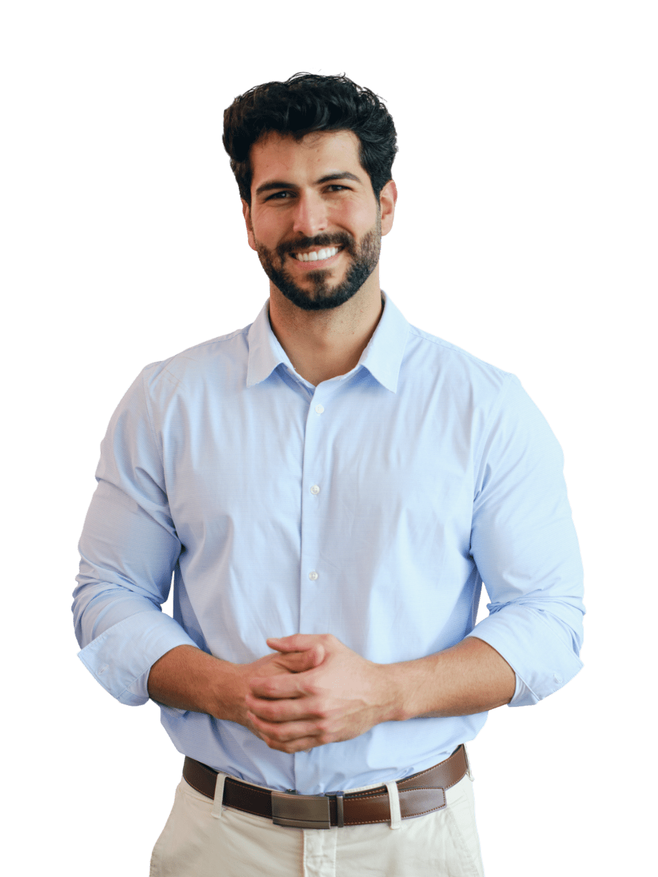 Smiling man in a light blue shirt standing with hands clasped.