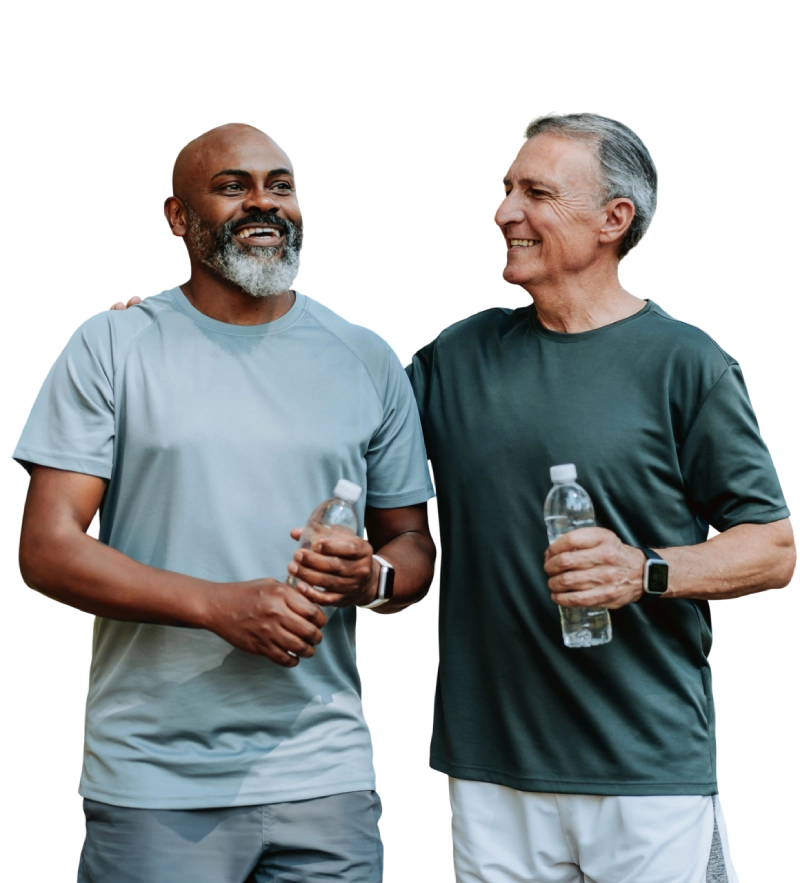 Two men smiling and holding water bottles, enjoying a walk together.