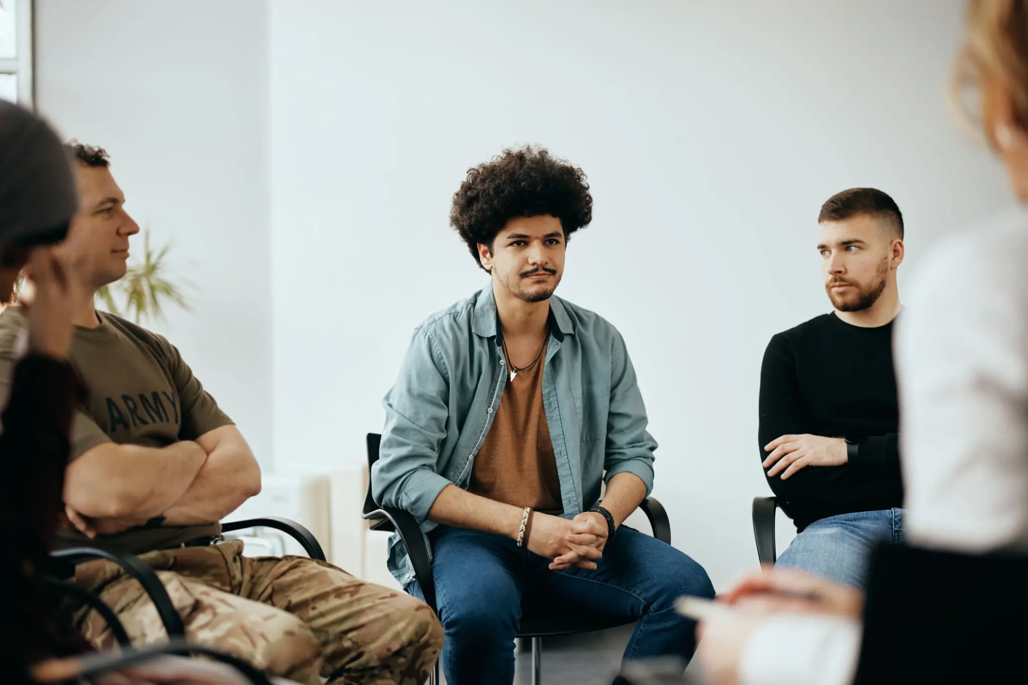 A group of young adults engaged in a discussion in a casual setting.