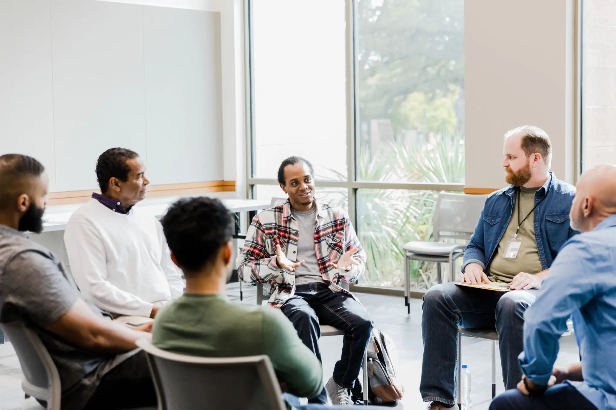 A diverse group engaged in a wheelchair-inclusive meeting.